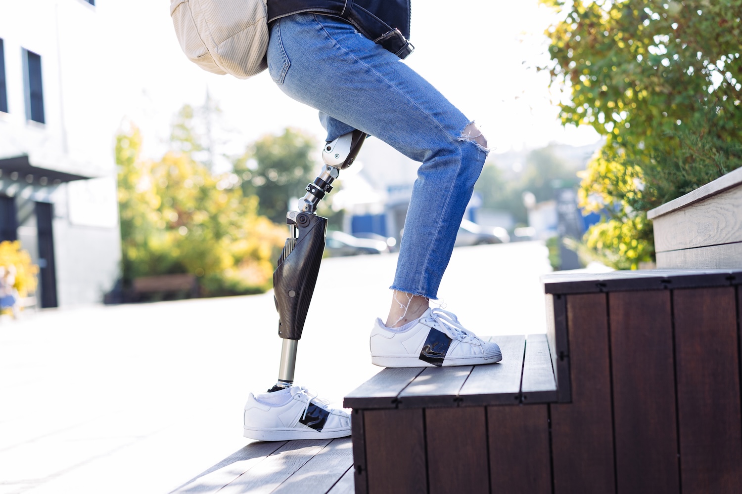 A person with a leg prosthetic walks up a staircase
