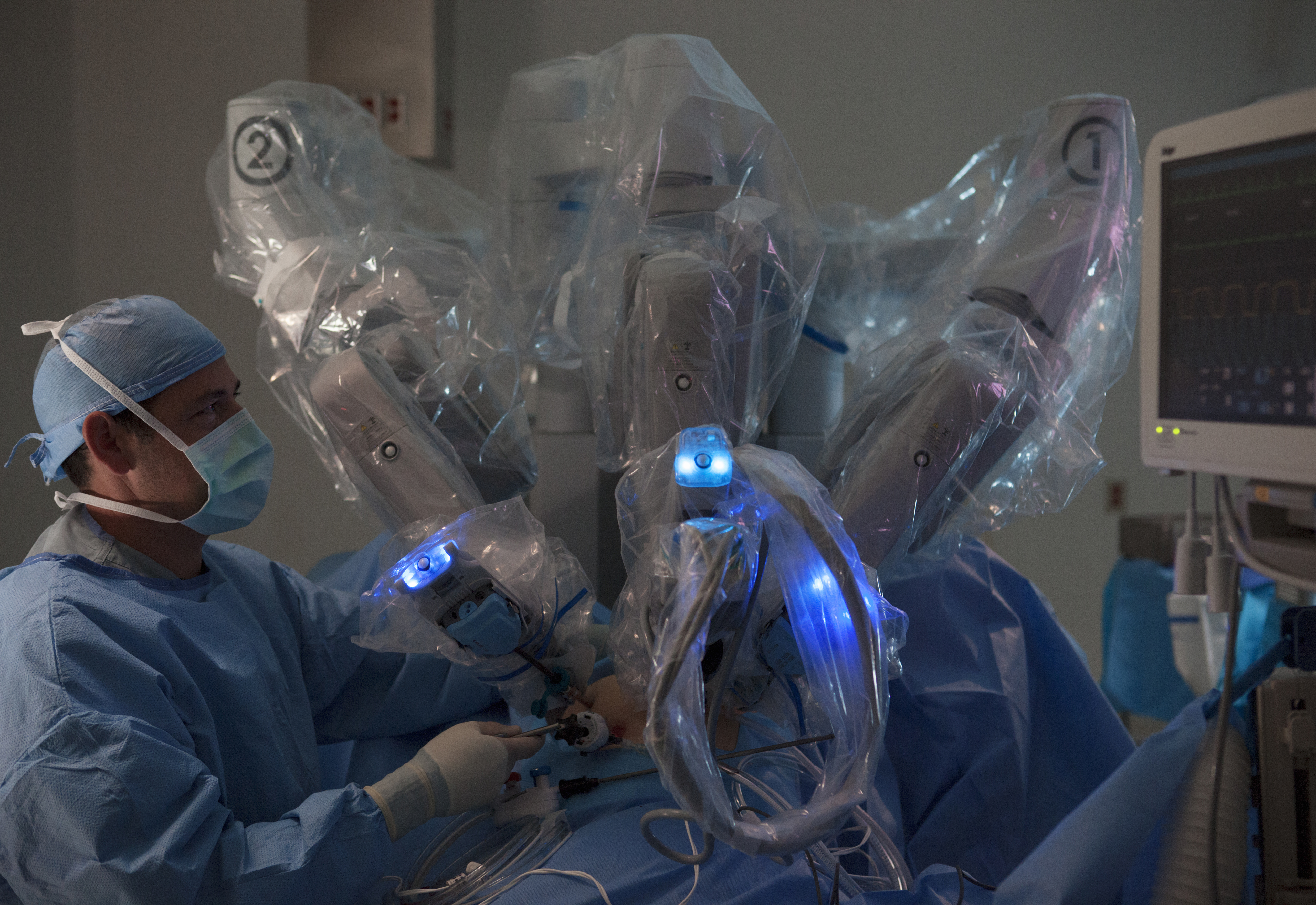 a robotic surgery machine is being used by a surgeon