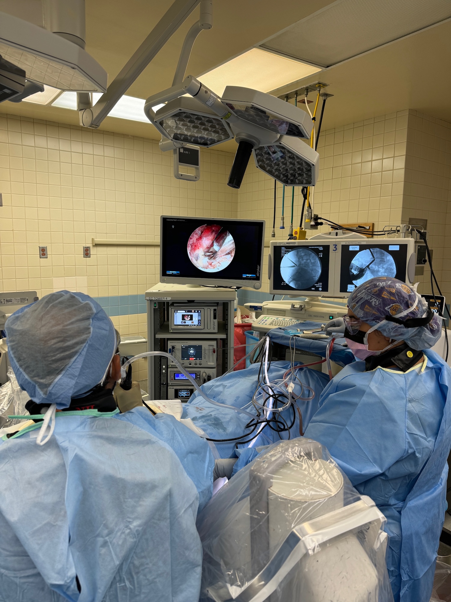 Doctors in blue scrubs operating during a spine surgery