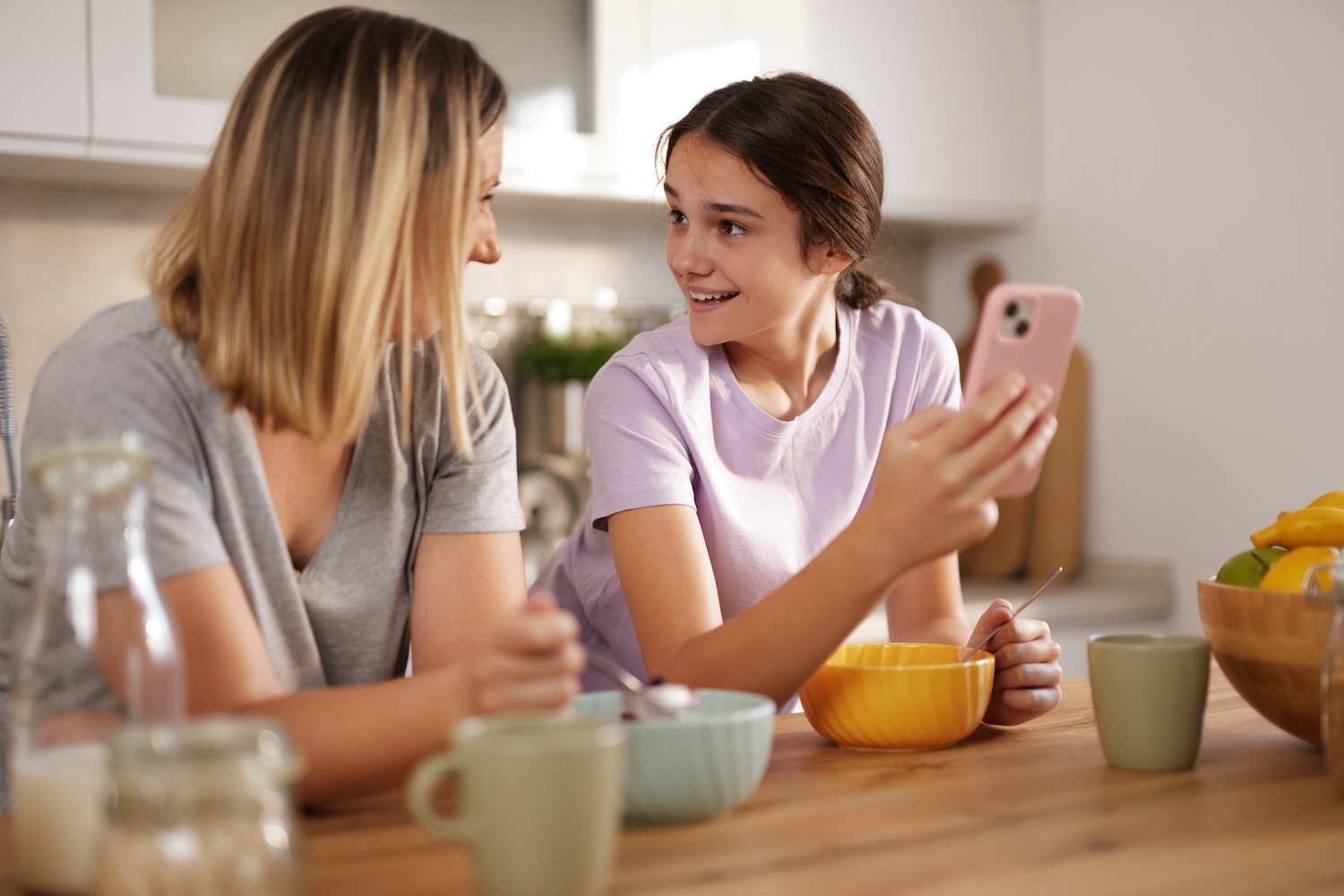 A Caucasian mother and daughter talk over breakfast 