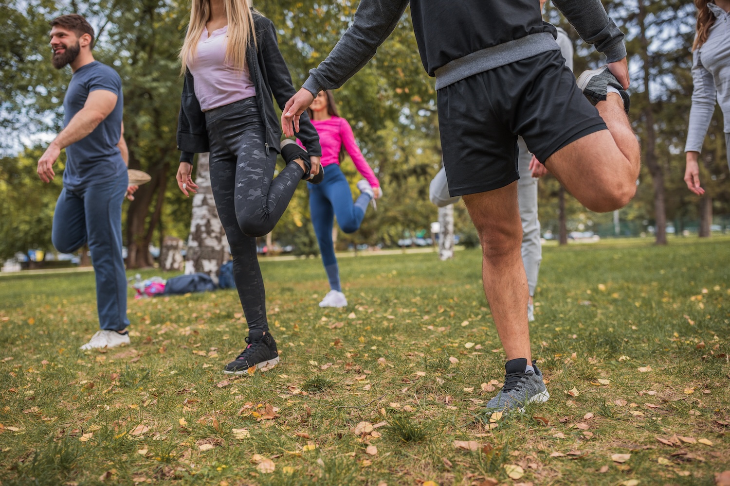 Several people stretching their legs in the park 