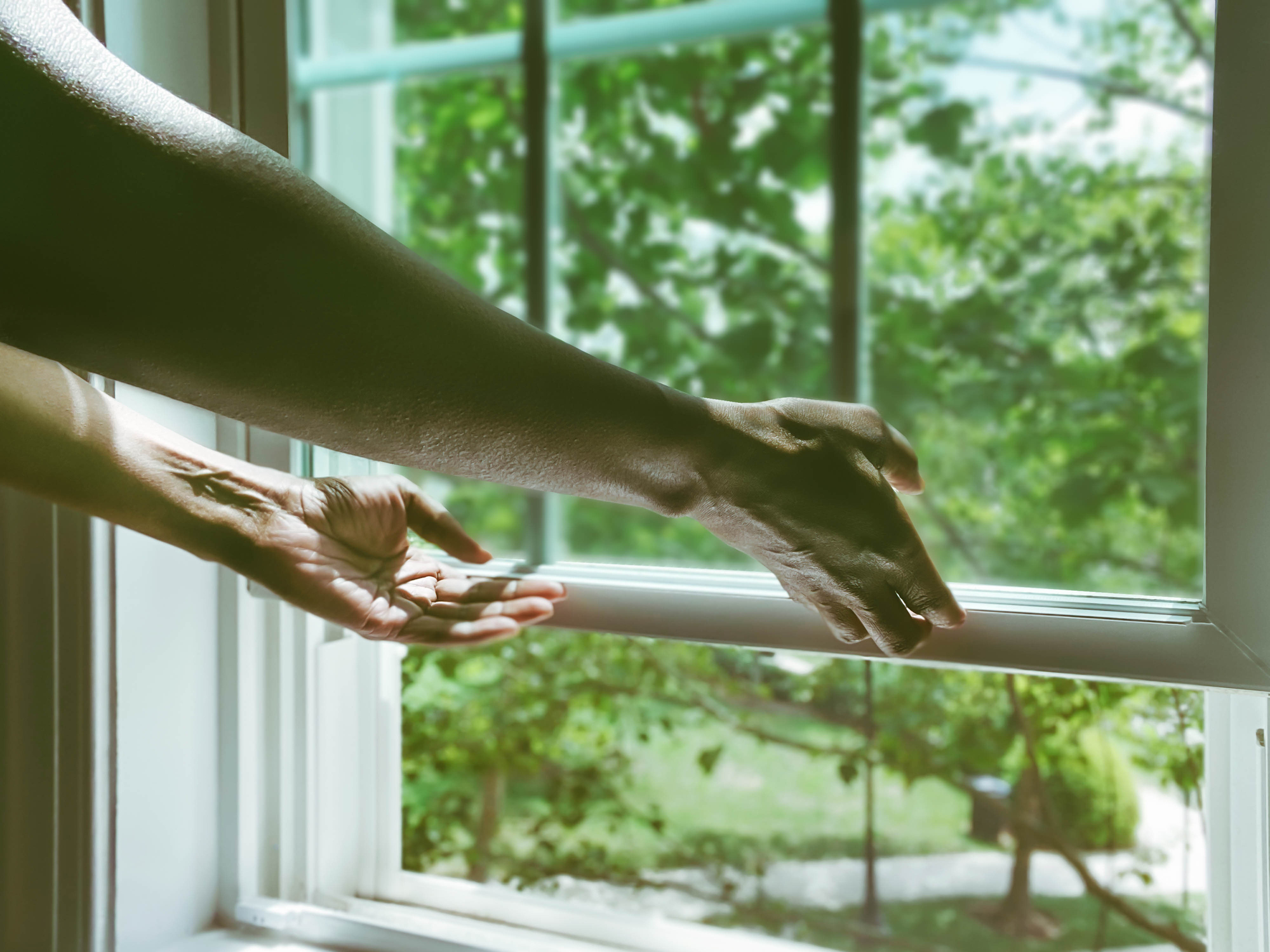 Close-up of woman's hands opening window