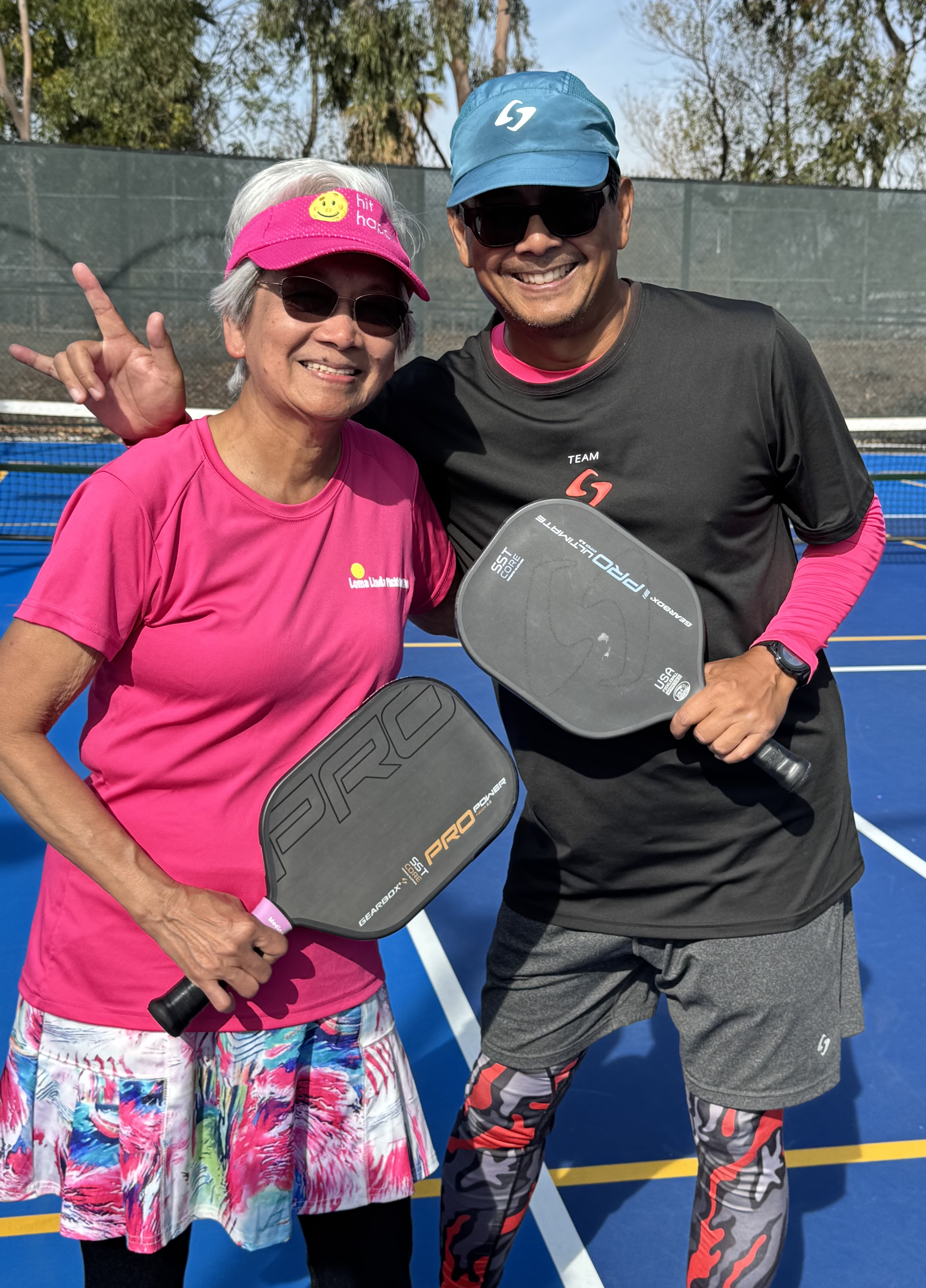 Ernie Medina and Loida Medina pose with pickleball paddles