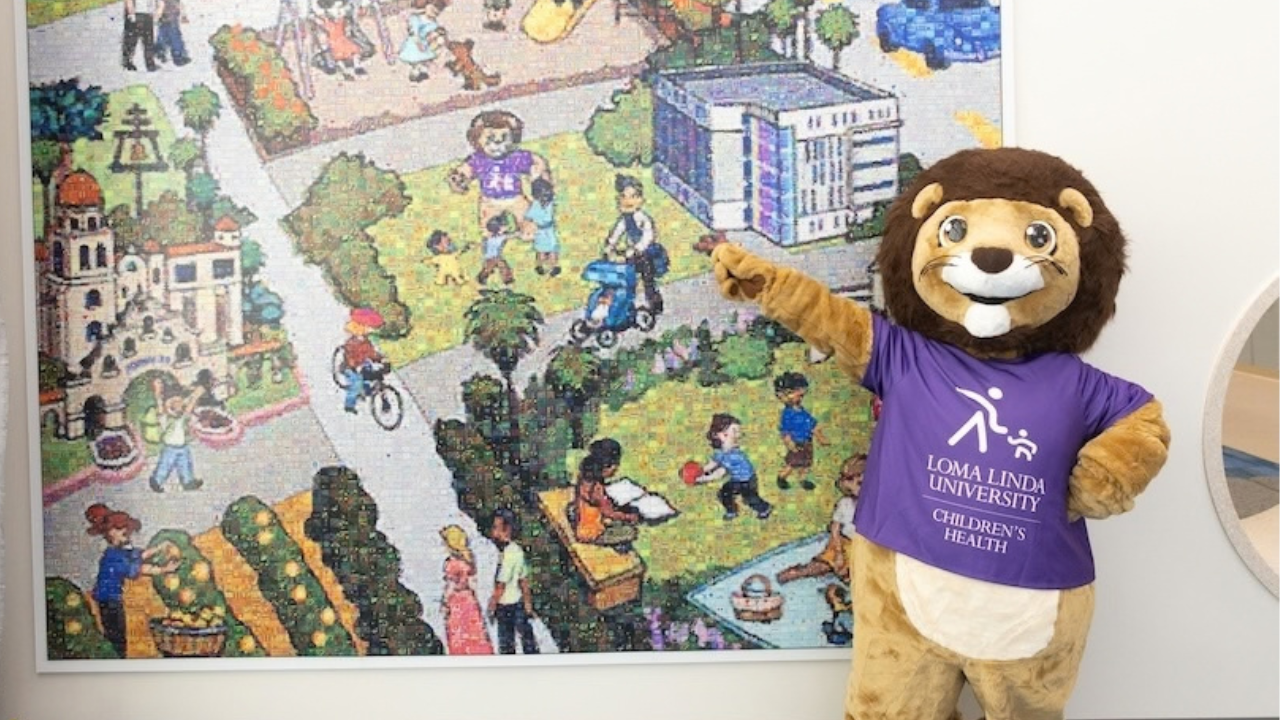 luke the lion poses in front of mural