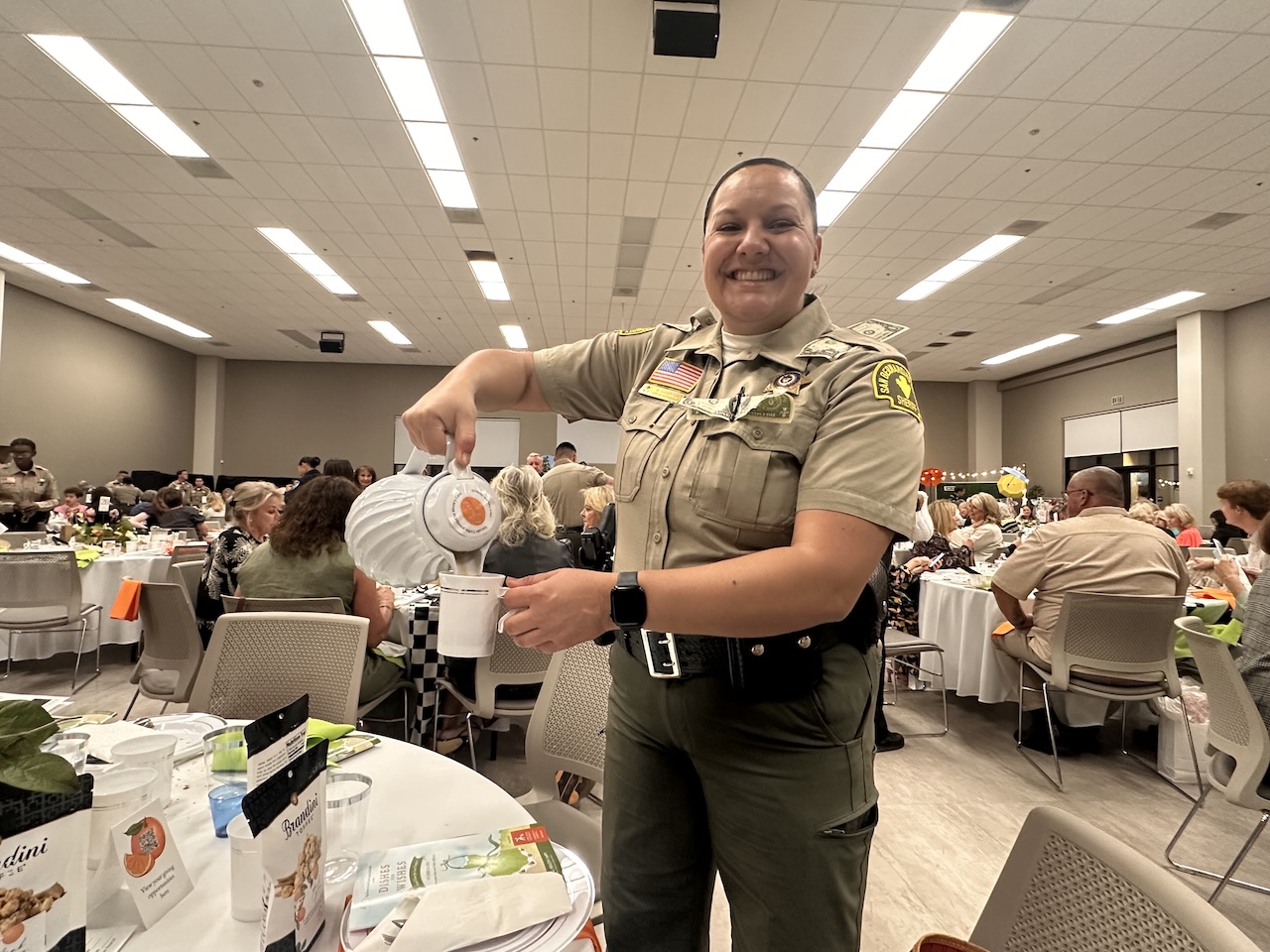 law enforcement officer pours coffee for guest