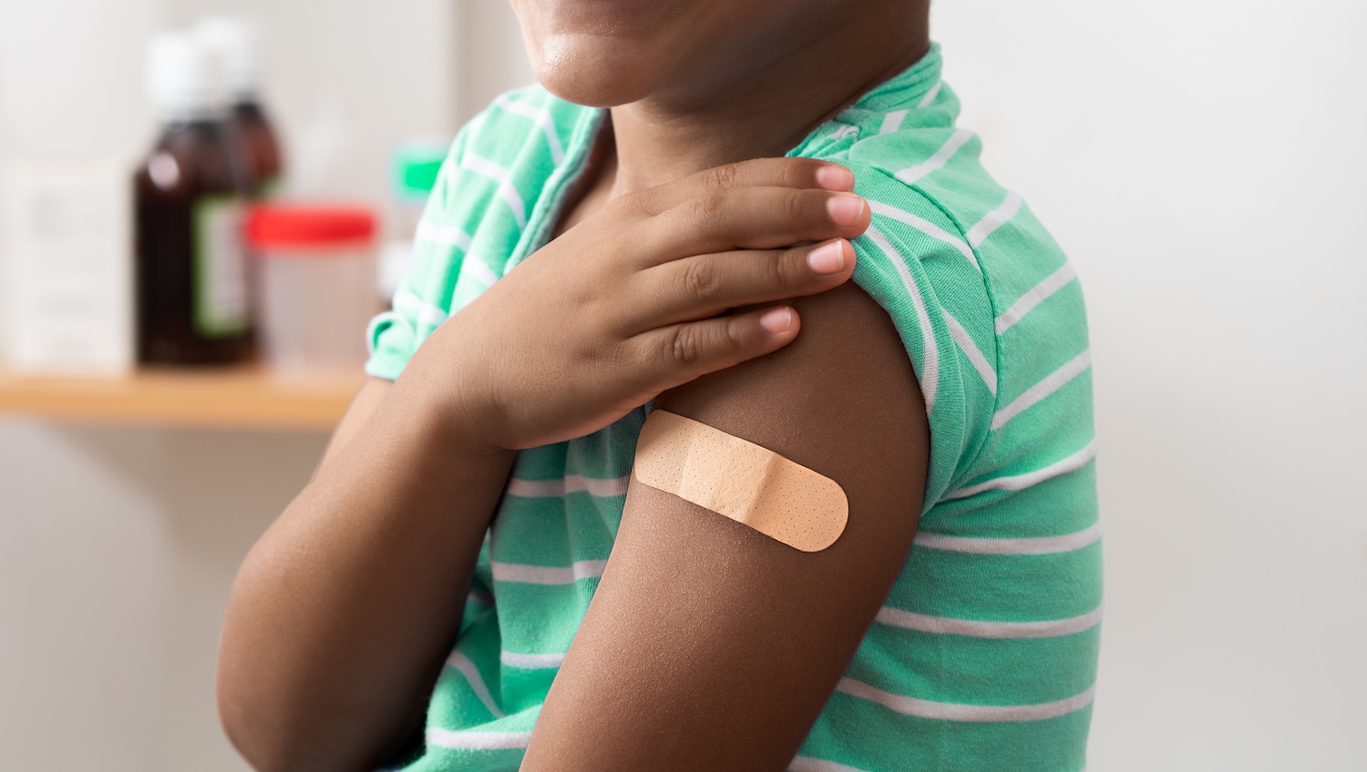 Vaccine and child with band aid on arm