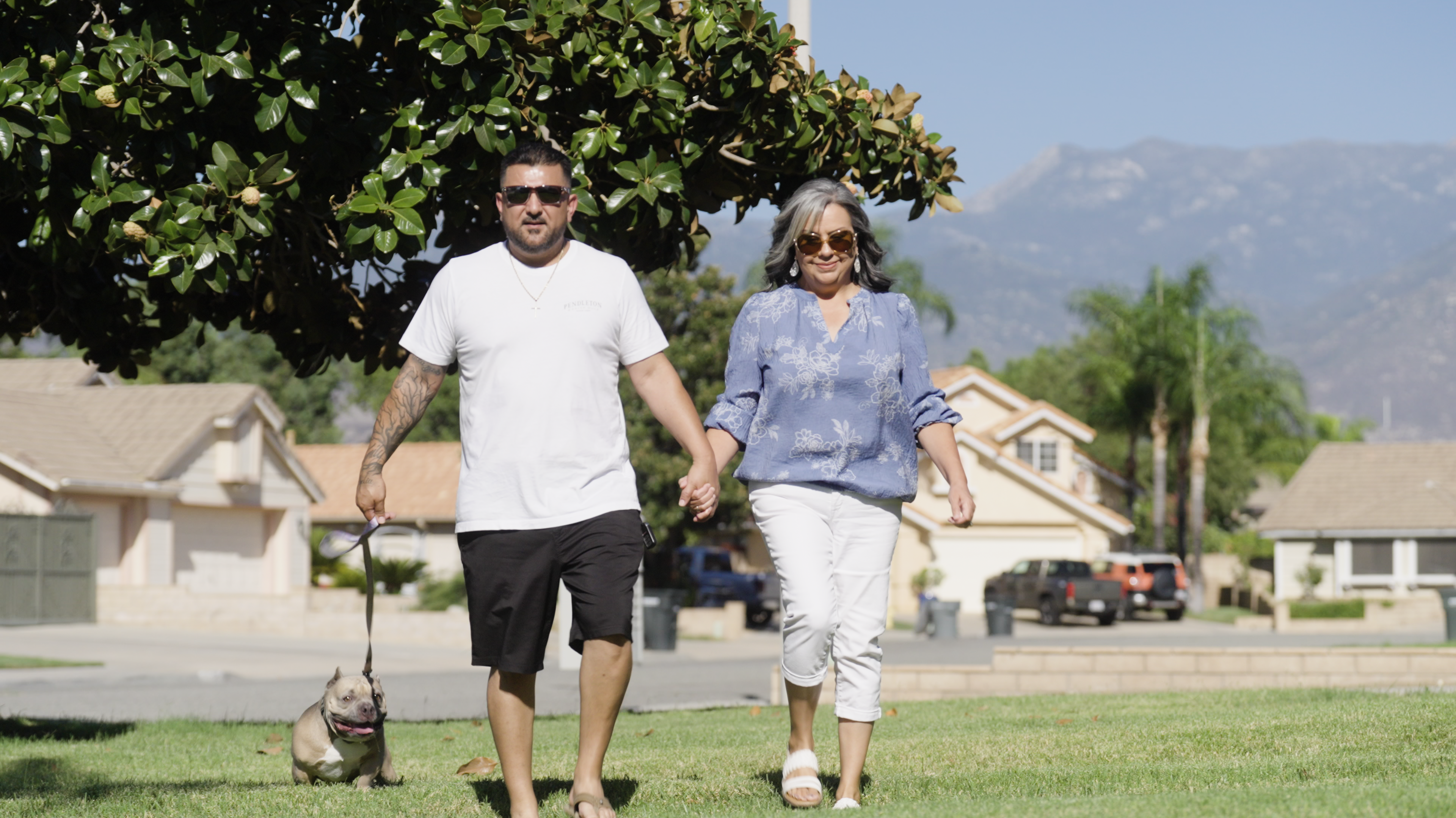 Dolores and Eleazar walking their dog outside