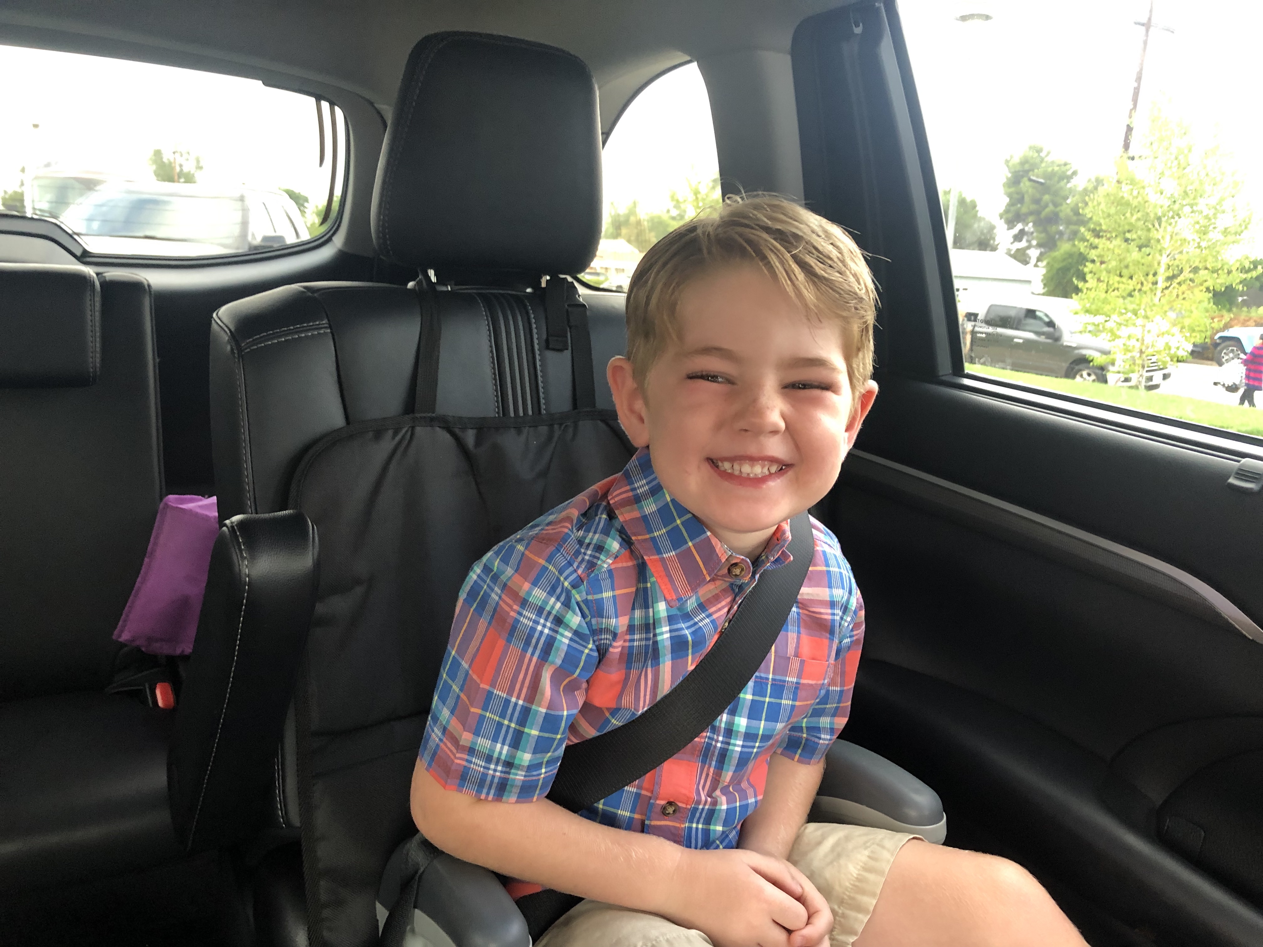 pre-school aged boy in booster seat and seatbelt