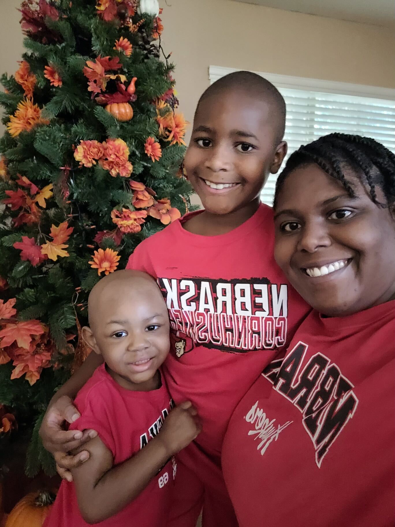 Black mom with her two young children, all wearing red
