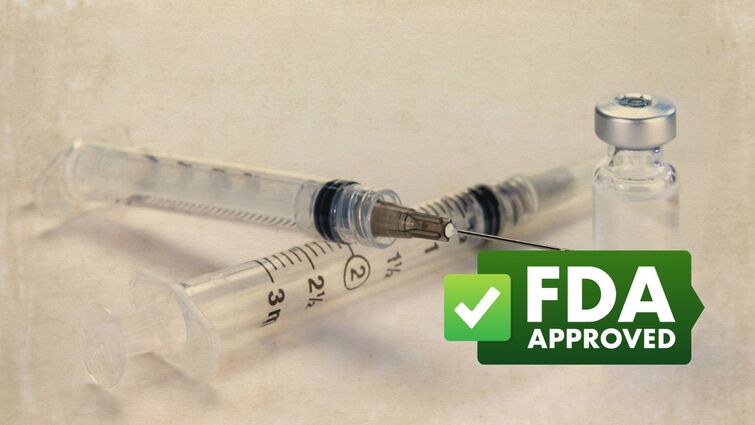 clear vaccine vial next to needle with green badge that says "FDA APPROVAL"