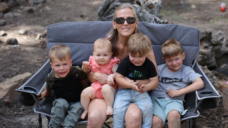 Lynn Olsen sitting with four small grandchildren