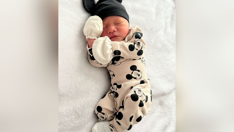 Newborn baby sleeping on bed