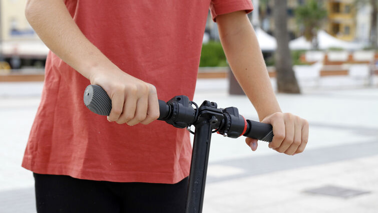Hands on handlebar of scooter, close-up