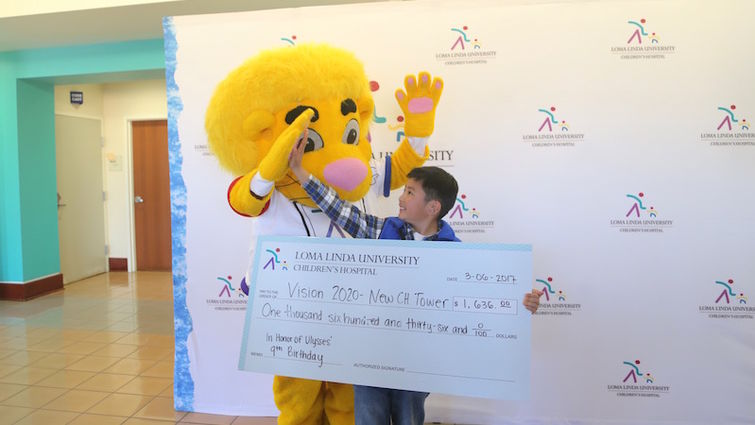 Ulysses Hsu high fives the Children’s Hospital mascot, Luke the Lion