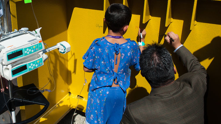 Rep. Pete Aguilar (right) signs one of the pedestals that will support the new hospital. Next to him is LLUCH patient Mark Varela, 9, from Riverside. Pete Aguilar signing a pedestal with a patient