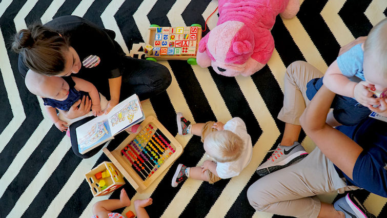 Event volunteers and staff from Child Life Services provided free child care at the 2nd annual Baby Conference Arial photo of adult female with toddlers.