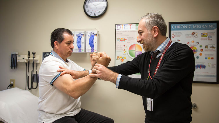 Male physician tests male patient's strength