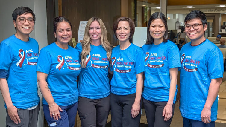 A group of people in blue shirts stand together