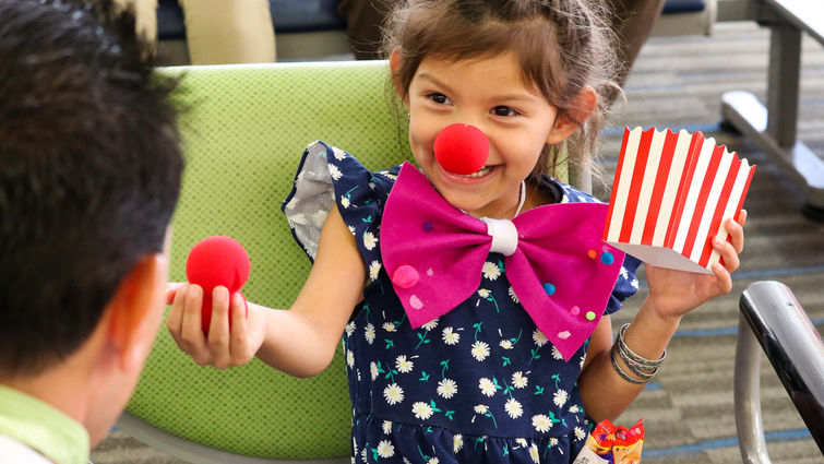 little girl with red nose and popcorn