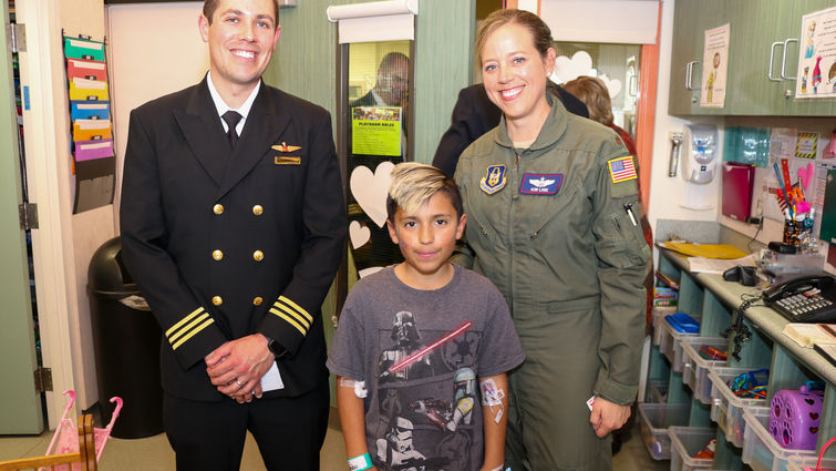 male and female pilot pose for photo with young male patient