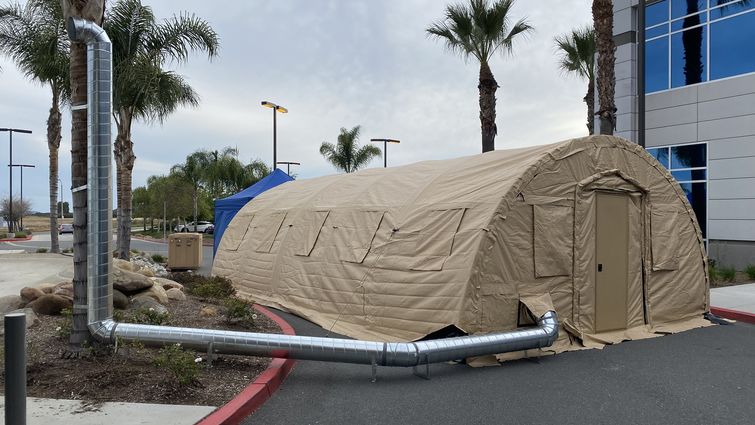 tan medical tent next to hospital