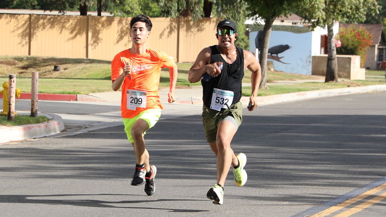 Two men running to the finish line at the Stand Up to Stigma 5K