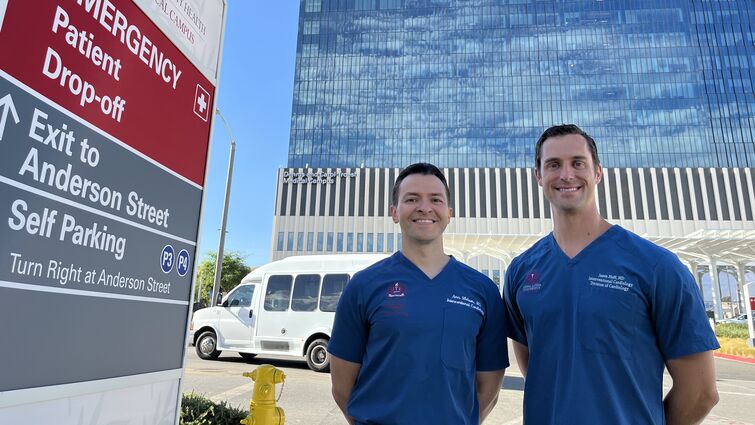 Two men stand in front of a medical building