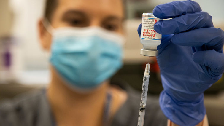A Loma Linda University Health employee prepares to administer a COVID-19 vaccine. 
