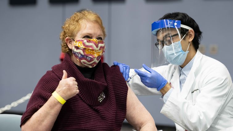 Patient receives COVID booster shot while giving a thumbs up Patient receives COVID booster shot while giving a thumbs up