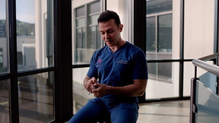 a man is holding a medical device and looking down at it 