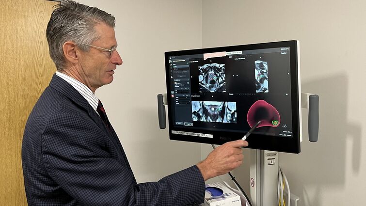 A doctor reviews a scan of a patient's prostate 