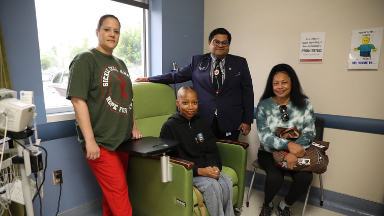 Family sits smiling with doctor in office