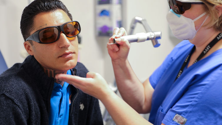 Dr. Burruss uses a laser to remove a tattoo on David Loya's face.