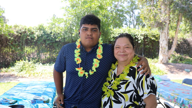 Son and his mother standing together to pose for camera