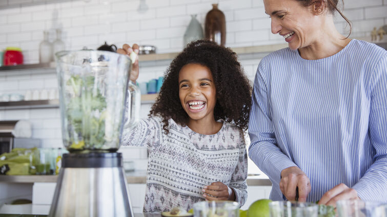Little girl and woman making a smoothie