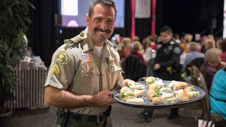 police officer holding tray of food for guests