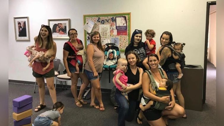 Moms gathered in class posing for birth and beyond support group photo