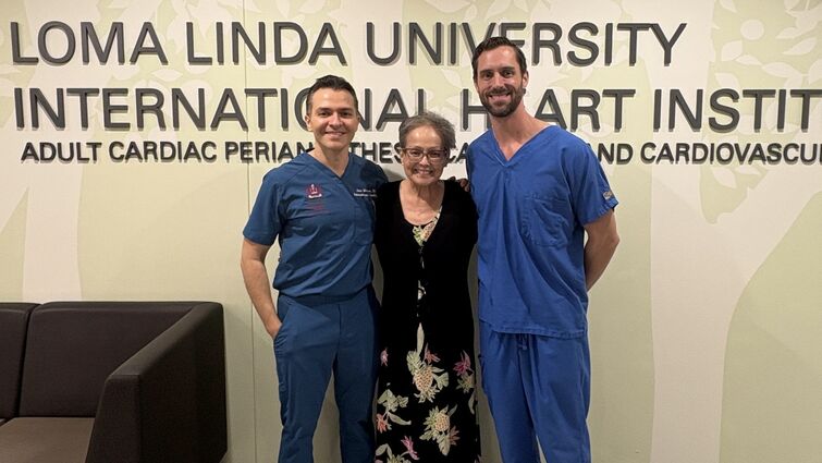 a woman poses with two men beside her all smiling 
