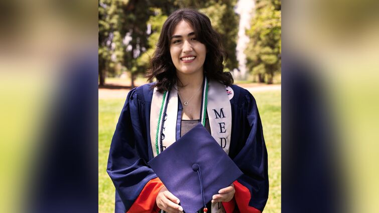 Zoe Gomez poses in a graduation gown