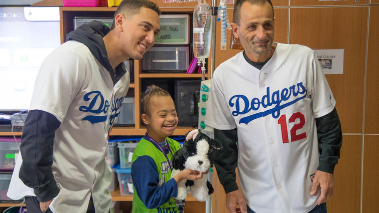 two baseball players pose for picture with young male patient 