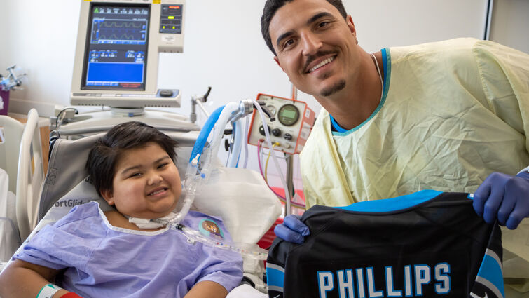 Phillips poses with a young patient