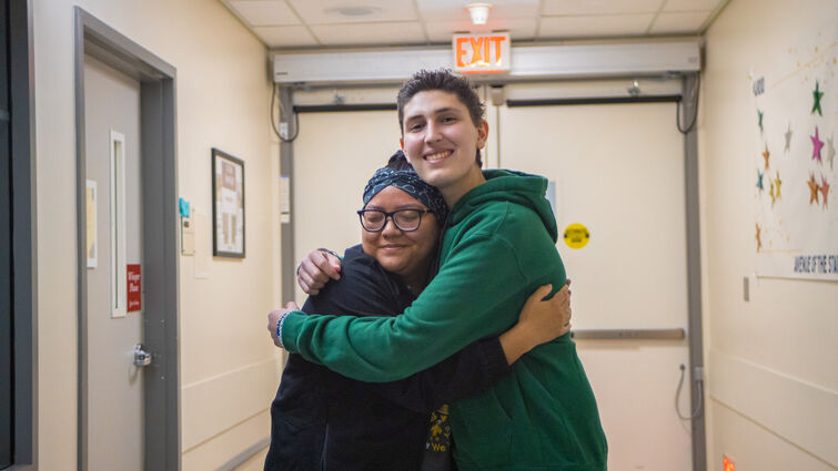 pediatric cancer patient hugs member of nursing staff