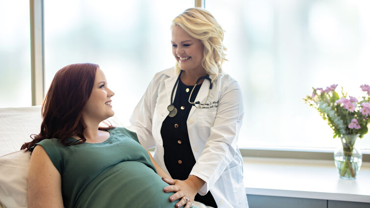 Dr. Courtney Martin stands bedside with pregnant patient