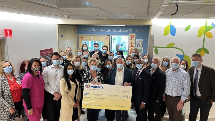 Group of people in a hospital hallway during a check presentation