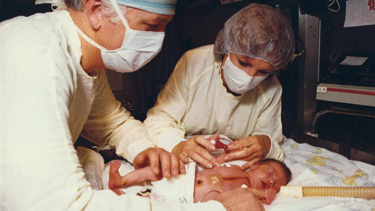 Surgeon Leonard Bailey and immunologist Sandra Nehlsen-Cannarella spend a few moments with Baby Fae. lluh