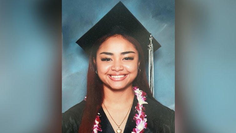 Abigail Aguilar smiling in a cap and gown in a formal graduation photo. 