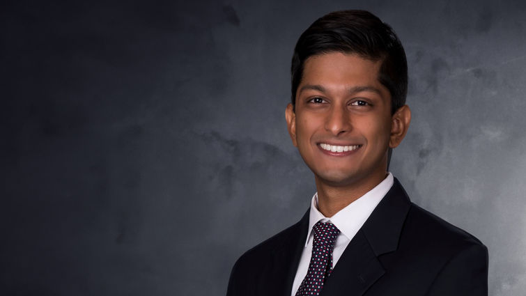 dark-skinned man in black suit and tie portrait style