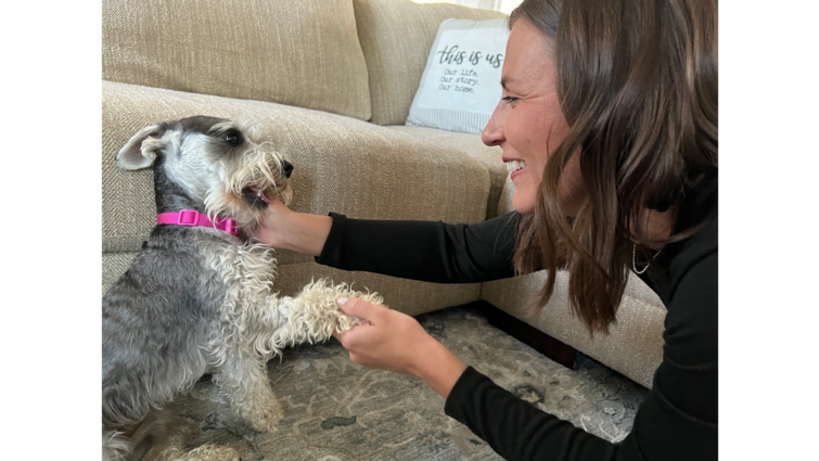 Woman playing with small dog smiling