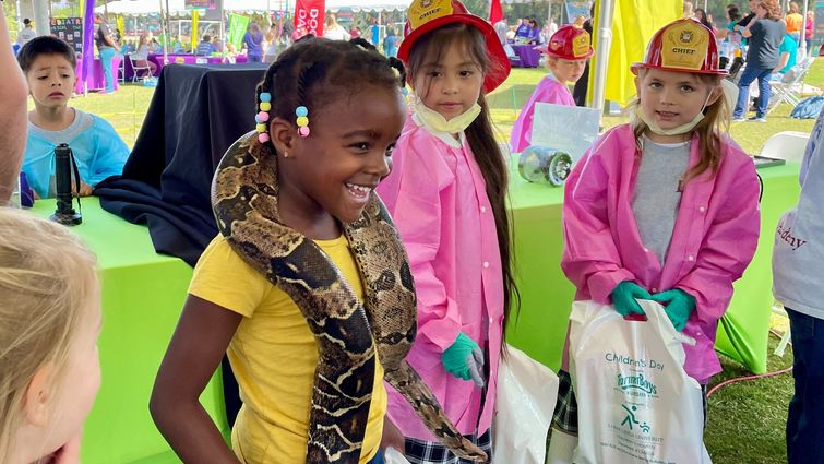 Girl particpates in health fair event and has snack around her neck