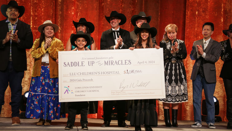 group wearing country-themed attire, including two young children, present a large check